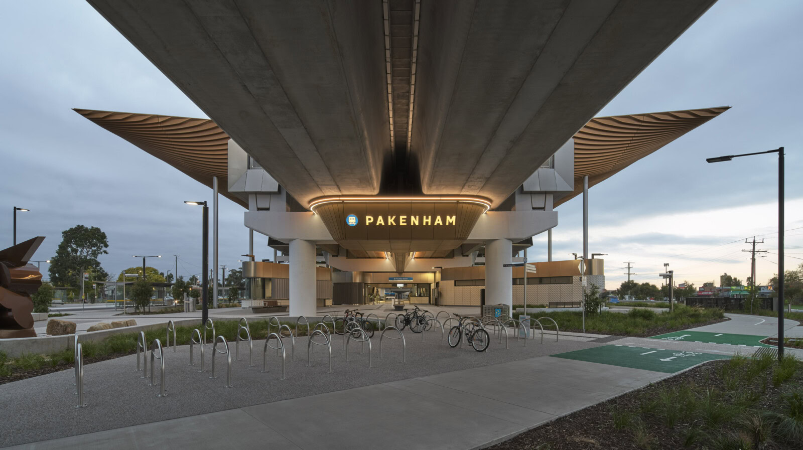 Pakenham Station Melbourne rail architecture viewed from below, showing elevated structure, station signage, and bike path access