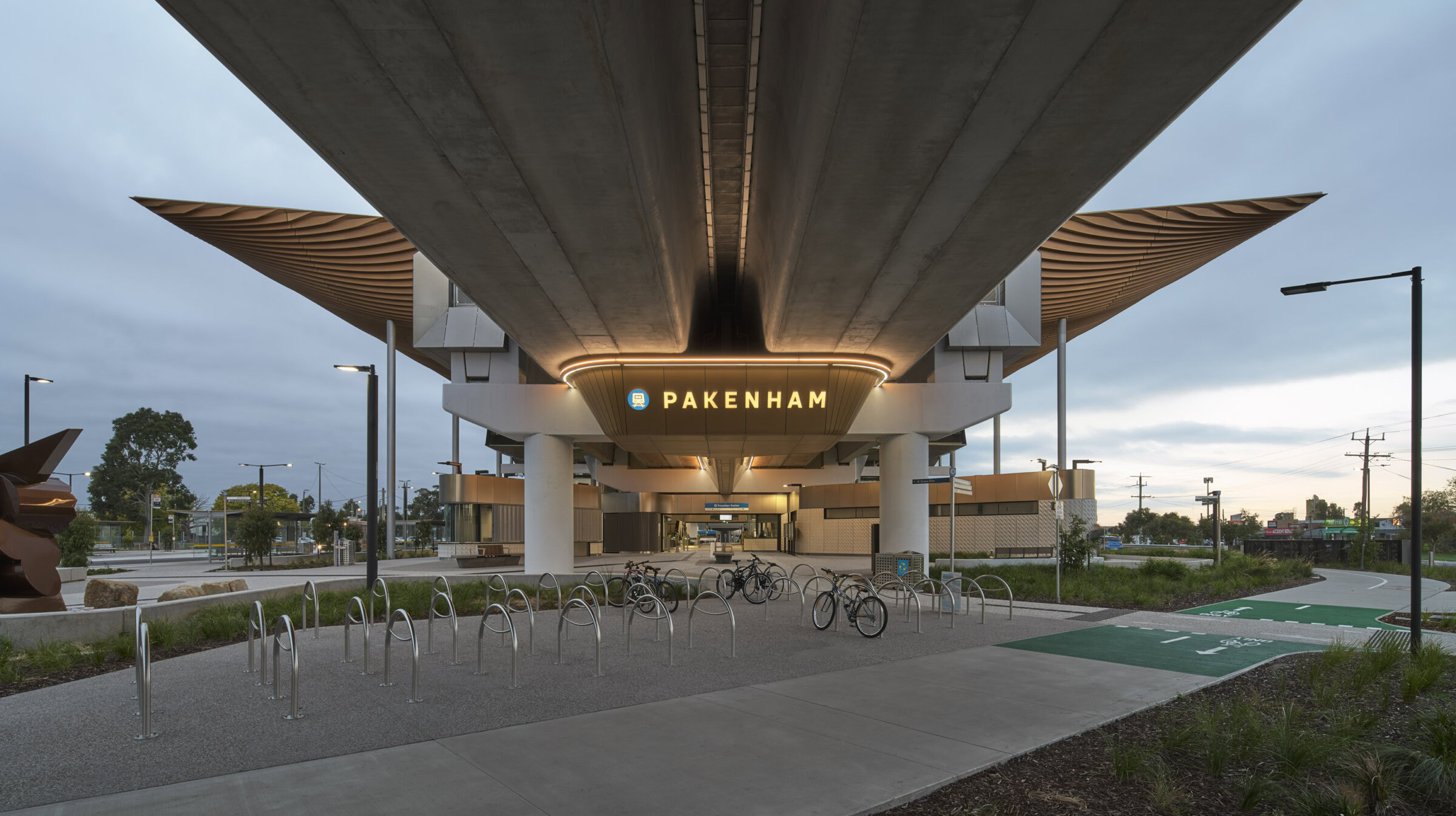 Pakenham Station Melbourne rail architecture viewed from below, showing elevated structure, station signage, and bike path access