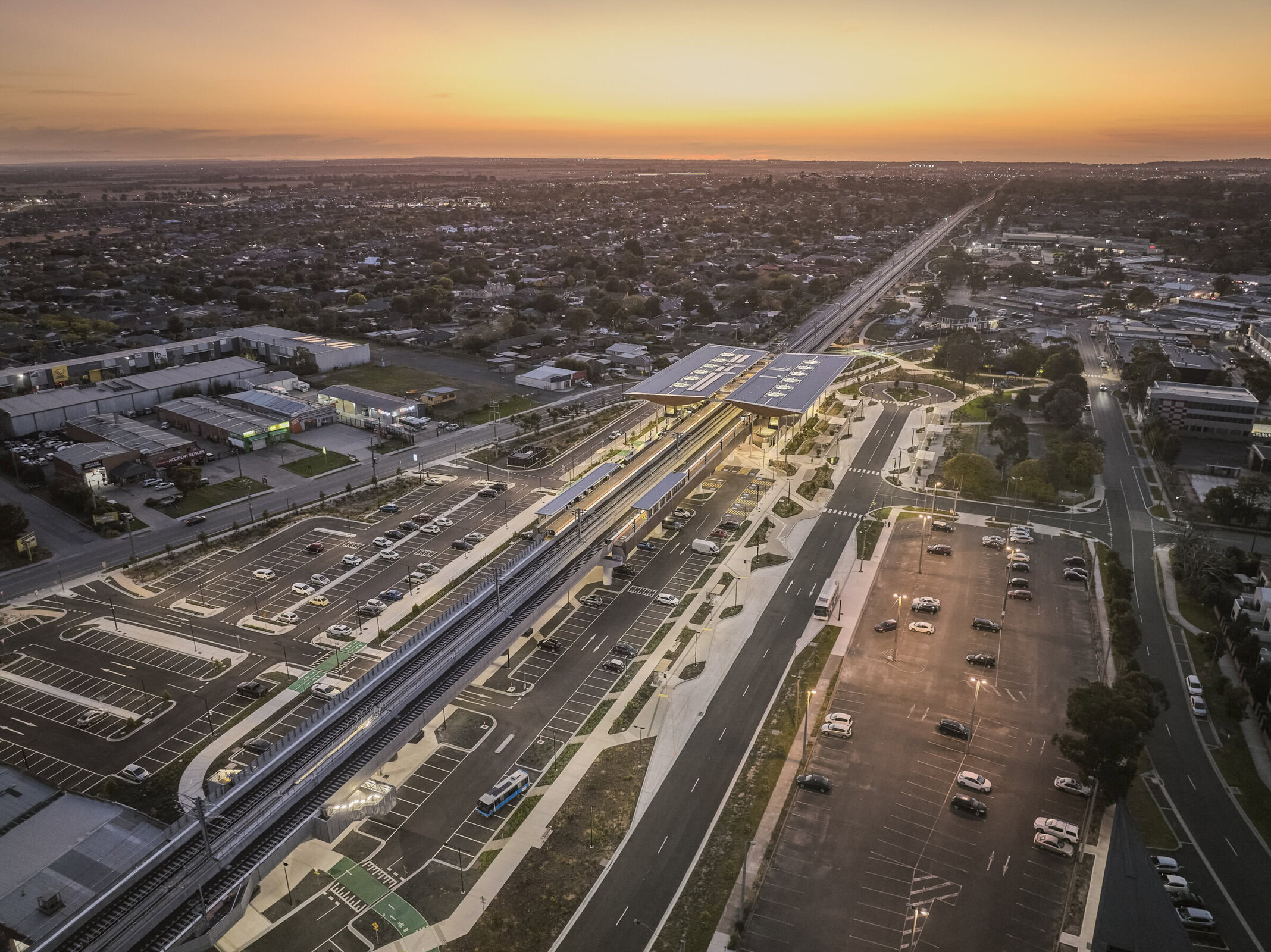 Aerial view of Pakenham Station Melbourne rail architecture at sunset, showing elevated structure, car parks, and surrounding urban context