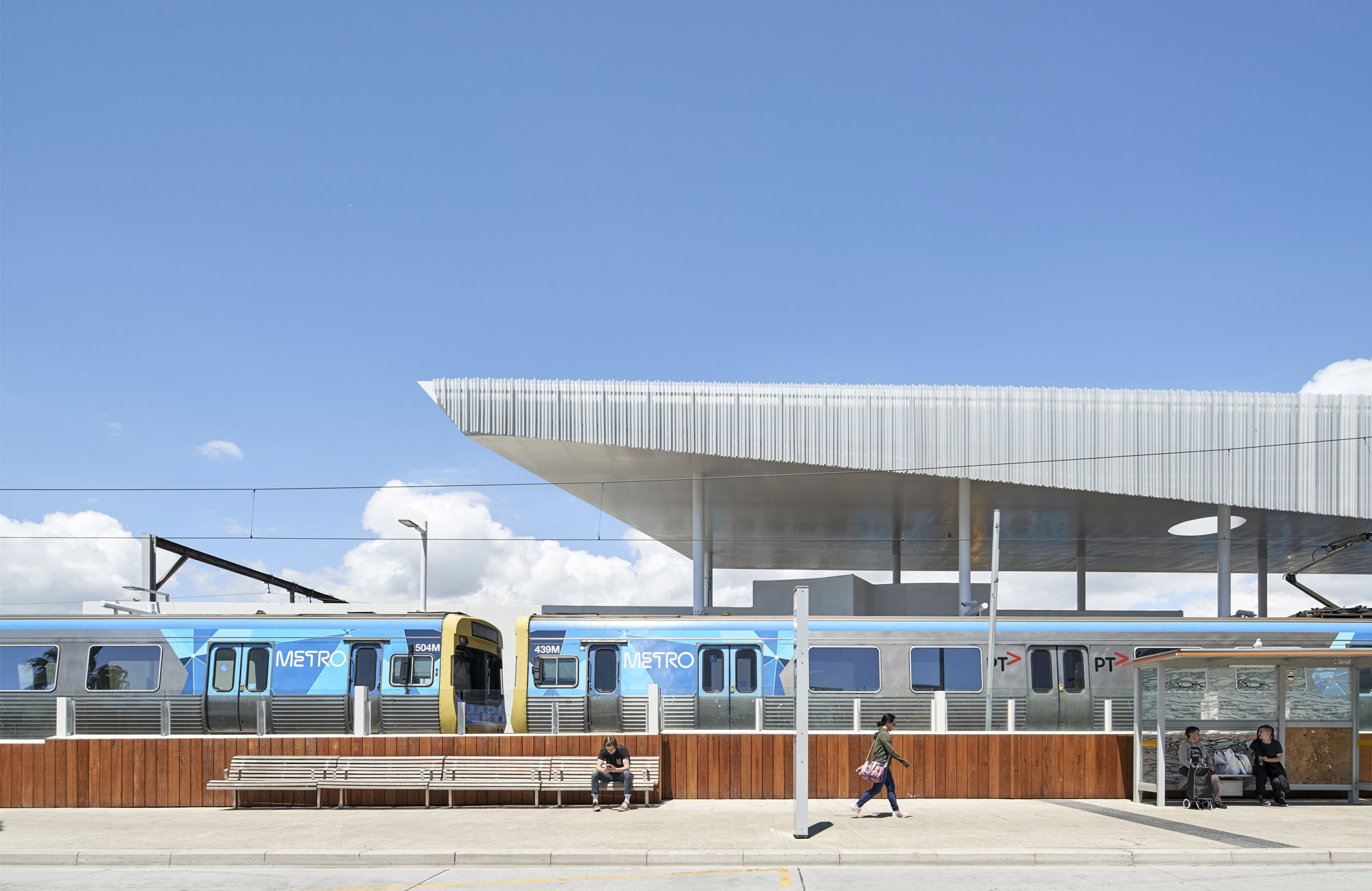 Frankston Station Melbourne rail architecture platform with a Metro train beneath the floating canopy, showcasing the station’s beachside-inspired architectural design.