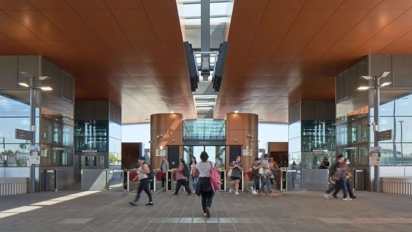 Glenroy Station exterior with angular roof and green forecourt, showcasing Genton’s Melbourne rail architecture