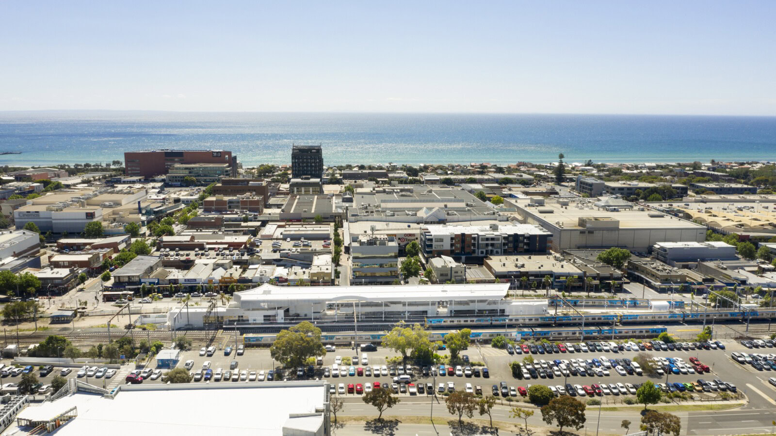 Frankston Station Melbourne rail architecture aerial view of Frankston Station and surrounding precinct, showing the rail corridor, town centre, and coastline beyond.
